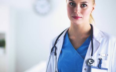 Kadın doktor hastanede steteskopla dikiliyor.