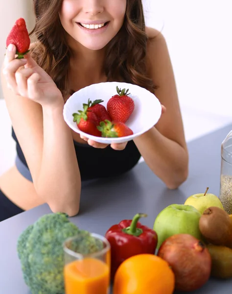 En leende kvinna som äter jordgubbar. Närbild kvinnligt ansikte porträtt — Stockfoto