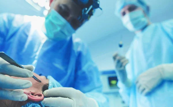 Homem cirurgião no trabalho na sala de cirurgia — Fotografia de Stock