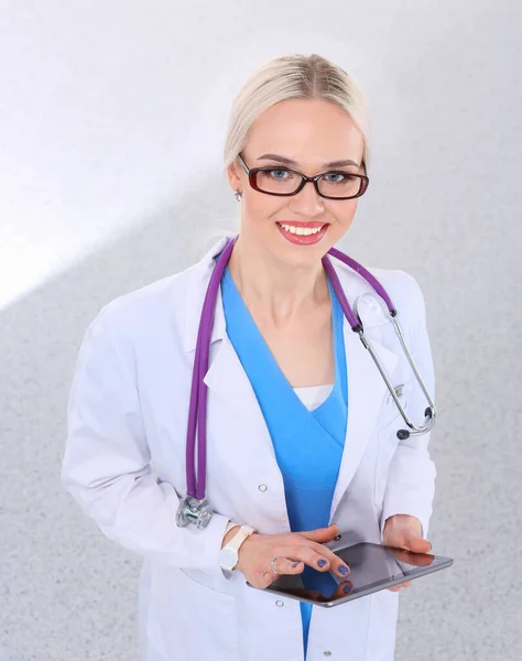 Женщина врач с помощью цифровой таблетки и стоя на белом фоне. Женщины-врачи. — стоковое фото