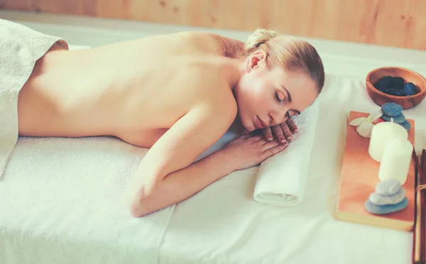 Piękna młoda kobieta dostaje masaż spa, leżąc na salonie — Zdjęcie stockowe