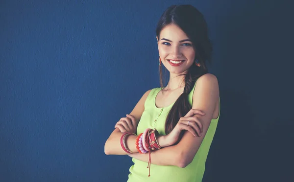 Mujer joven de pie cerca de la pared oscura —  Fotos de Stock