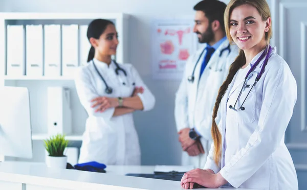 Attractive female doctor in front of medical group — Stock Photo, Image