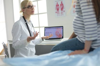 Hastanede doktorla gülümseyen güzel bir hamile kadın.