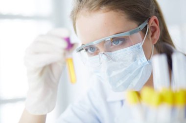 Modern laboratuvar veya hastanede plastik tıbbi tüplerle çalışan araştırmacı, doktor, bilim adamı veya laboratuvar asistanı