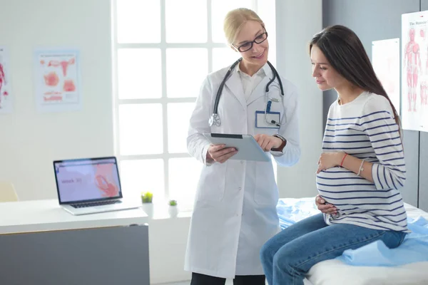 Schöne lächelnde Schwangere mit dem Arzt im Krankenhaus — Stockfoto