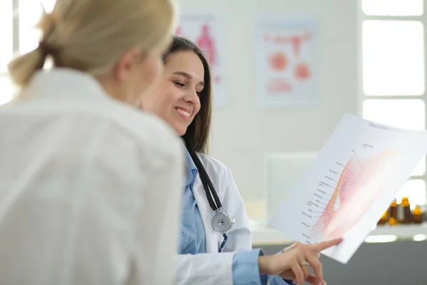 Dottore e paziente discutono di qualcosa mentre sono seduti al tavolo. Medicina e concetto di assistenza sanitaria — Foto Stock