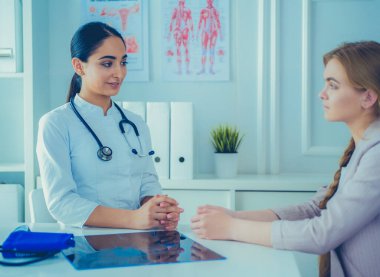 Hastanenin penceresinin yanındaki masada oturan doktor ve hastayı kapat.