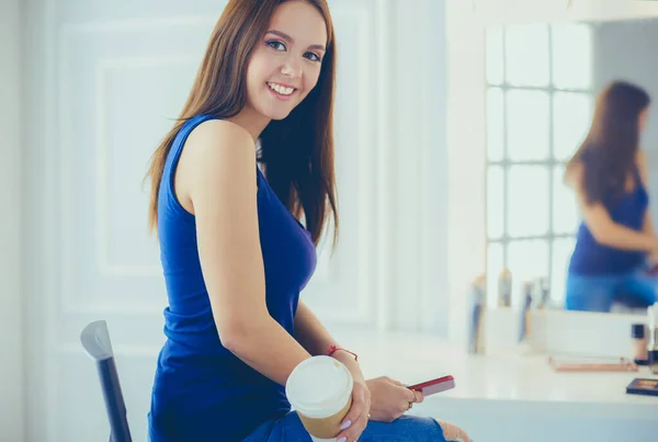 Mujer joven en la cafetería bebiendo café y hablando por teléfono móvil — Foto de Stock