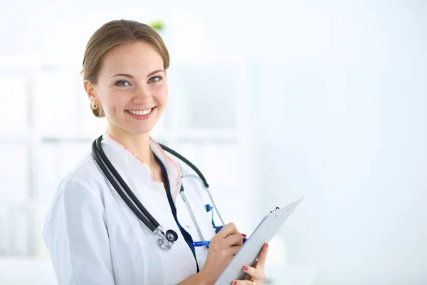 Женщина-врач стоит с папкой в больнице — стоковое фото