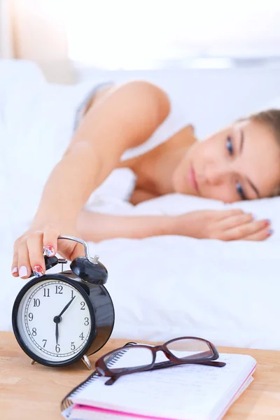 Eine junge Frau stellt morgens ihren Wecker aus — Stockfoto