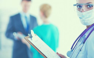 Kadın doktor hastanede dosyayla bekliyor.