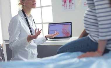 Hastanede doktorla gülümseyen güzel bir hamile kadın.