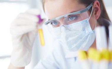 Modern laboratuvar veya hastanede plastik tıbbi tüplerle çalışan araştırmacı, doktor, bilim adamı veya laboratuvar asistanı