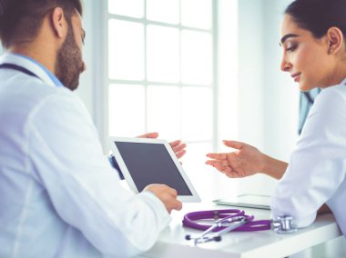 Tıbbi ekip masada oturup tartışıyor.