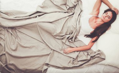 Evdeki yatakta uzanmış güzel esmer