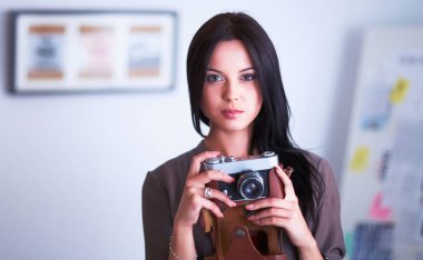 Genç bir kadın film izliyor, pencerenin yanında duruyor.