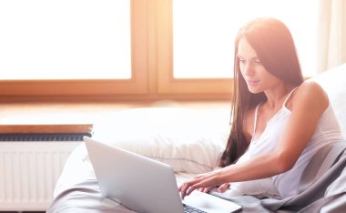 Evdeki yatakta uzanmış güzel esmer