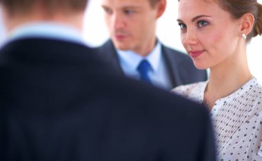 İş kadını ofisteki meslektaşlarına sunum yaparken yazı tahtasında yazıyor.