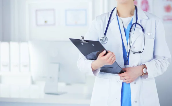 Médecin souriante avec un dossier en uniforme debout — Photo