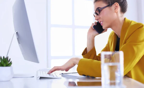 Retrato de una hermosa mujer haciendo una llamada mientras está sentada en su lugar de trabajo frente a la computadora portátil y trabajando en un nuevo proyecto —  Fotos de Stock