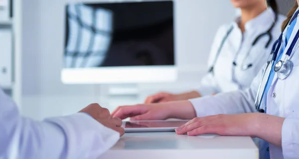 Équipe médicale assise et discutant à table — Photo