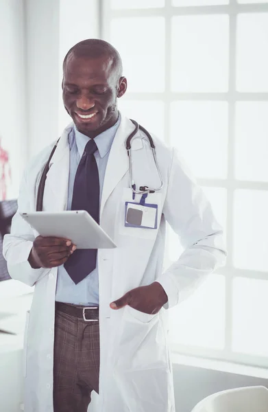 Male black doctor worker with tablet computer standing in hospital