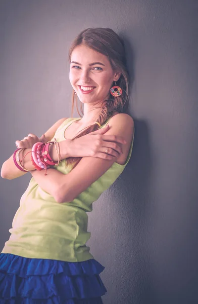 Portret van een jonge glimlachende vrouw op een grijze achtergrond — Stockfoto