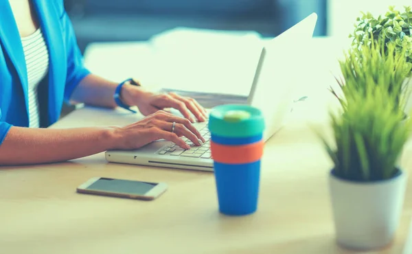 Mujer sentada en el escritorio con portátil — Foto de Stock