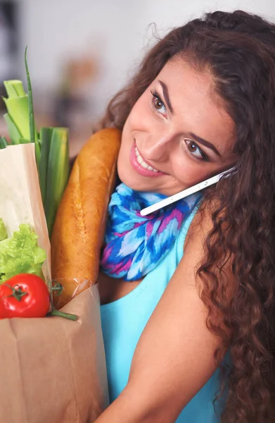 Young woman holding grocery shopping bag with vegetables Standing in the kitchen. — Stock Photo, Image