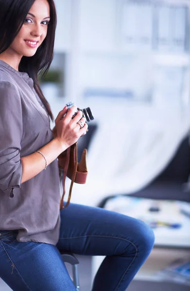 Mujer joven viendo imágenes en la película, de pie cerca de la ventana — Foto de Stock