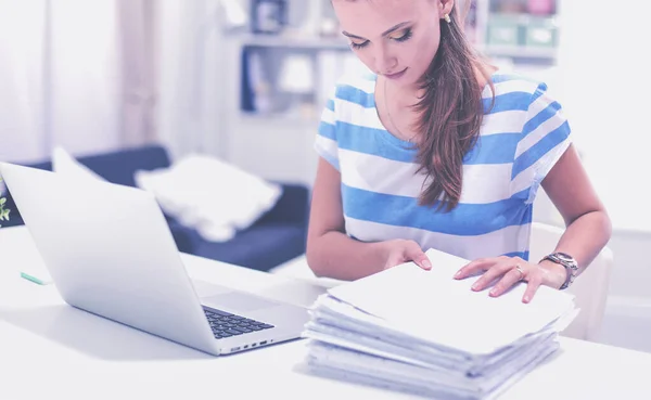 Smiling woman with documents sitting on the desk with laptop. — Stock Photo, Image
