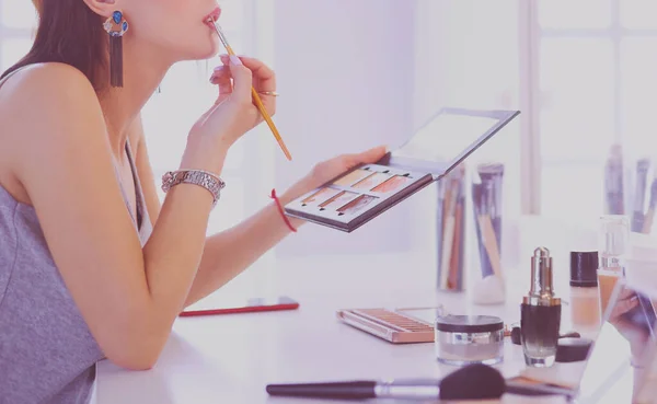 Brunette woman applying make up for a evening date in front of a mirror — Stock Photo, Image