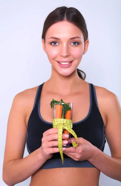 Mulher segurando um copo cheio de salada de frutas frescas com uma fita métrica ao redor do copo — Fotografia de Stock