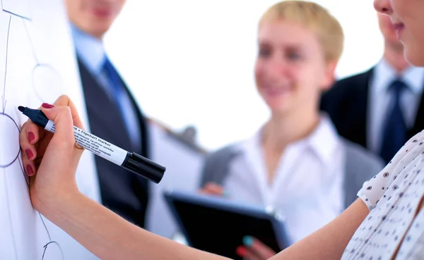 Femme d'affaires écrivant sur un tableau à feuilles mobiles tout en donnant une présentation à ses collègues au bureau — Photo