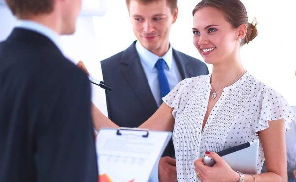 Femme d'affaires écrivant sur un tableau à feuilles mobiles tout en donnant une présentation à ses collègues au bureau — Photo