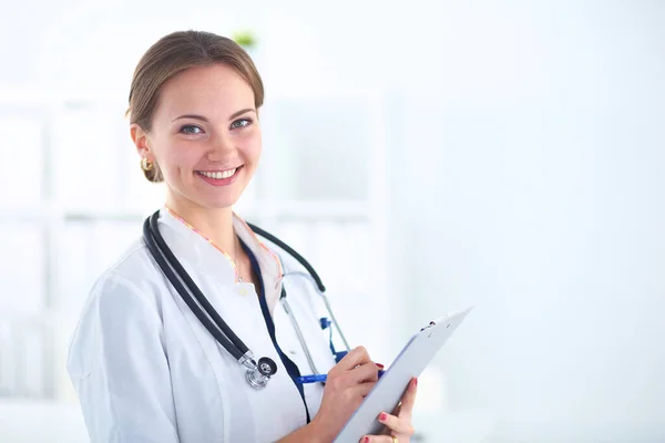 Woman doctor standing with folder at hospital — Stock Photo, Image