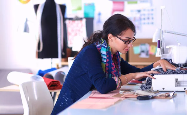 Mujer joven cosiendo sentado en su lugar de trabajo —  Fotos de Stock