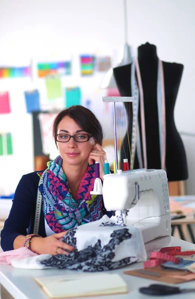 Giovane donna cucire mentre seduto al suo posto di lavoro — Foto Stock