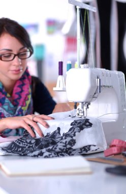 Çalışırken dikiş diken genç bir kadın.