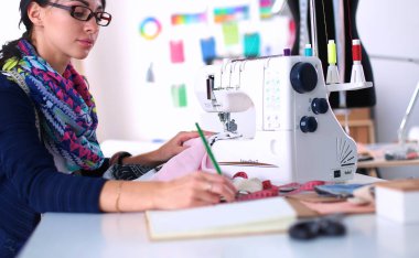 Çalışırken dikiş diken genç bir kadın.