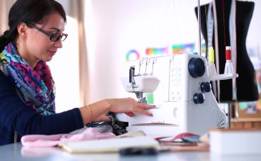 Çalışırken dikiş diken genç bir kadın.