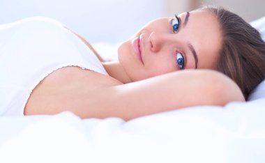 Genç ve güzel bir kadın yatakta yatıyor.