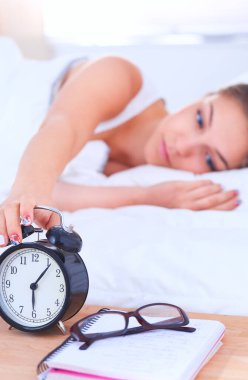 Genç bir kadın sabah alarmını erteliyor.