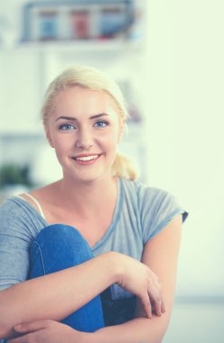 Genç ve güzel bir kadın odasında kanepede oturuyor.