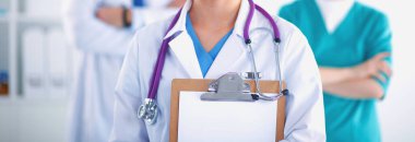 Kadın doktor hastanede dosyayla bekliyor.