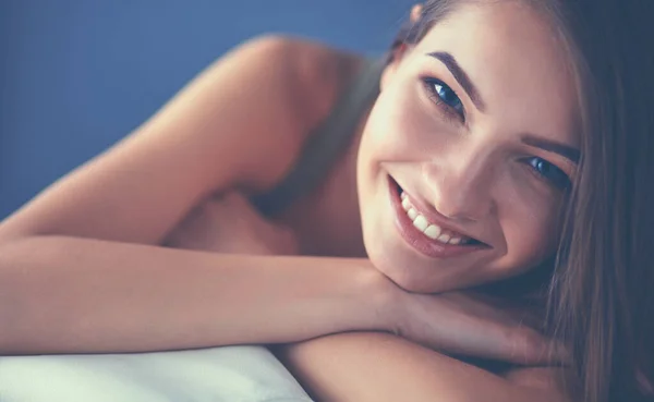 Closeup of a smiling young woman lying on couch — Stock Photo, Image