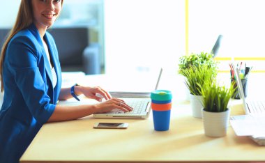Masada dizüstü bilgisayarı olan kadın.