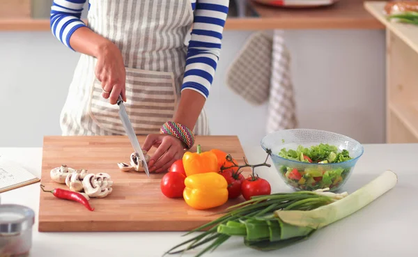 Mujer joven cortando verduras en la cocina —  Fotos de Stock