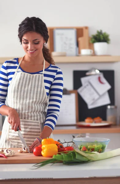 Mujer joven cortando verduras en la cocina —  Fotos de Stock